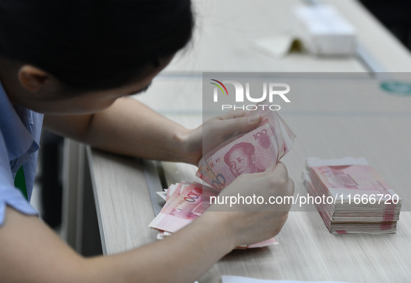 A contestant competes to identify counterfeit currency during a professional skills competition in the banking industry's currency and gold...