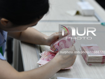 A contestant competes to identify counterfeit currency during a professional skills competition in the banking industry's currency and gold...