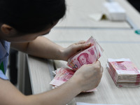 A contestant competes to identify counterfeit currency during a professional skills competition in the banking industry's currency and gold...