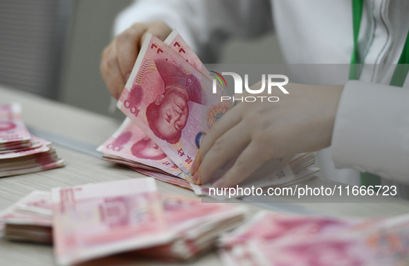 A contestant competes to identify counterfeit currency during a professional skills competition in the banking industry's currency and gold...