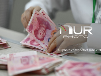 A contestant competes to identify counterfeit currency during a professional skills competition in the banking industry's currency and gold...