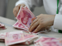 A contestant competes to identify counterfeit currency during a professional skills competition in the banking industry's currency and gold...