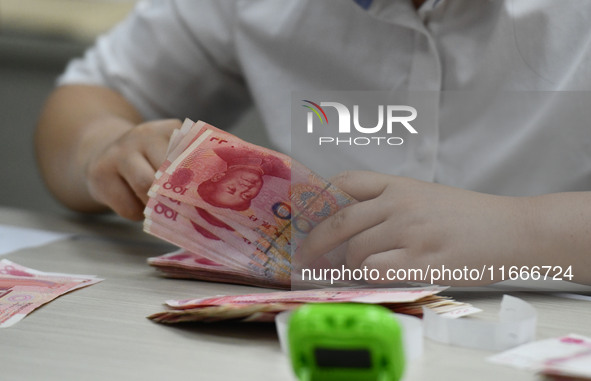 A contestant competes to identify counterfeit currency during a professional skills competition in the banking industry's currency and gold...