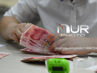 A contestant competes to identify counterfeit currency during a professional skills competition in the banking industry's currency and gold...