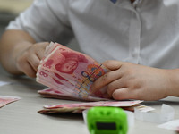 A contestant competes to identify counterfeit currency during a professional skills competition in the banking industry's currency and gold...