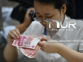 A contestant competes to identify counterfeit currency during a professional skills competition in the banking industry's currency and gold...