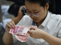 A contestant competes to identify counterfeit currency during a professional skills competition in the banking industry's currency and gold...