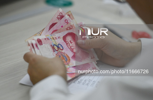 A contestant competes to identify counterfeit currency during a professional skills competition in the banking industry's currency and gold...