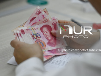 A contestant competes to identify counterfeit currency during a professional skills competition in the banking industry's currency and gold...