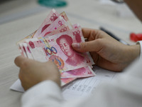 A contestant competes to identify counterfeit currency during a professional skills competition in the banking industry's currency and gold...