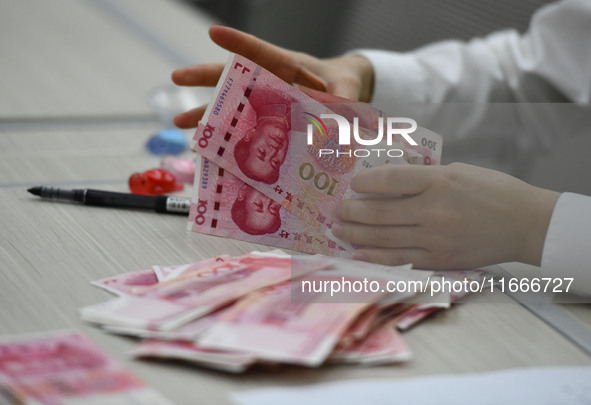 A contestant competes to identify counterfeit currency during a professional skills competition in the banking industry's currency and gold...