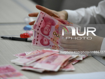 A contestant competes to identify counterfeit currency during a professional skills competition in the banking industry's currency and gold...