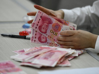 A contestant competes to identify counterfeit currency during a professional skills competition in the banking industry's currency and gold...