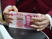 A bank employee uses a machine to count RMB during a vocational skills competition in the banking industry's currency gold and silver busine...