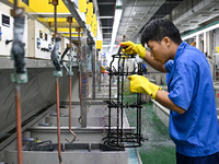 A worker electroplates metal jewelry at a jewelry processing plant in Jinhua, China, on October 15, 2024. (