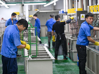 A worker electroplates metal jewelry at a jewelry processing plant in Jinhua, China, on October 15, 2024. (