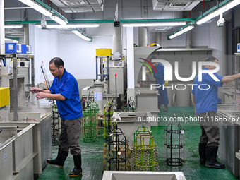 A worker electroplates metal jewelry at a jewelry processing plant in Jinhua, China, on October 15, 2024. (