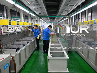 A worker electroplates metal jewelry at a jewelry processing plant in Jinhua, China, on October 15, 2024. (