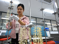 A worker sorts metal ornaments at a jewelry processing plant in Jinhua, China, on October 15, 2024. (