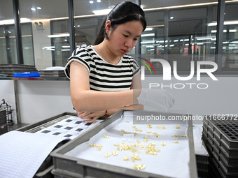 A worker sorts metal ornaments at a jewelry processing plant in Jinhua, China, on October 15, 2024. (