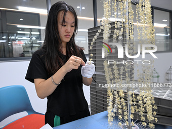 A worker sorts metal ornaments at a jewelry processing plant in Jinhua, China, on October 15, 2024. (