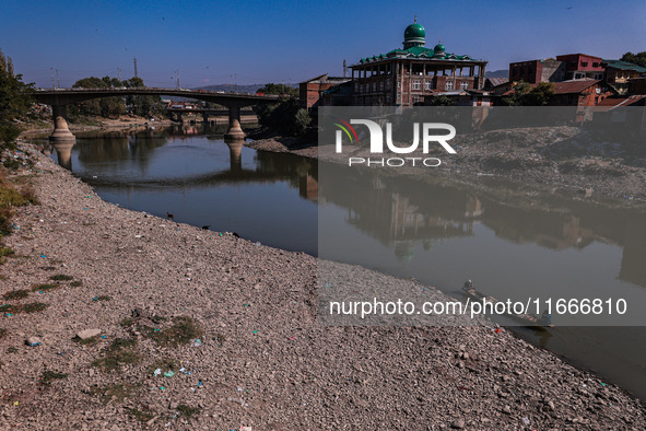 Kashmiri fishermen catch fish as a dry spell reduces the water level of the River Jhelum in Baramulla, Jammu and Kashmir, India, on October...