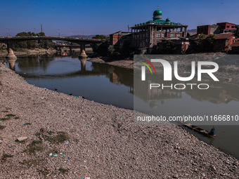 Kashmiri fishermen catch fish as a dry spell reduces the water level of the River Jhelum in Baramulla, Jammu and Kashmir, India, on October...