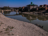 Kashmiri fishermen catch fish as a dry spell reduces the water level of the River Jhelum in Baramulla, Jammu and Kashmir, India, on October...