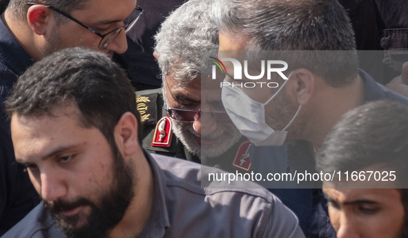 Brigadier General Esmail Qaani, Commander of the Quds Force of the Islamic Revolutionary Guard Corps, is escorted by unidentified men after...