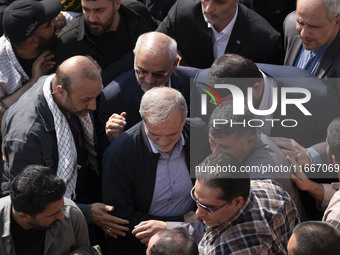 Iranian President Masoud Pezeshkian is escorted by his bodyguards after attending a funeral ceremony for General Abbas Nilforoushan, a comma...