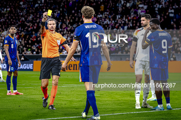 Referee Slavko Vincic gives Netherlands midfielder Mats Wieffer a yellow card during the match between Germany and the Netherlands at the Al...