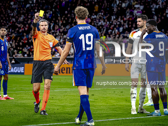 Referee Slavko Vincic gives Netherlands midfielder Mats Wieffer a yellow card during the match between Germany and the Netherlands at the Al...