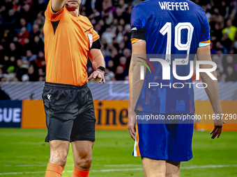 Referee Slavko Vincic gives Netherlands midfielder Mats Wieffer a yellow card during the match between Germany and the Netherlands at the Al...