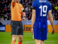 Referee Slavko Vincic gives Netherlands midfielder Mats Wieffer a yellow card during the match between Germany and the Netherlands at the Al...