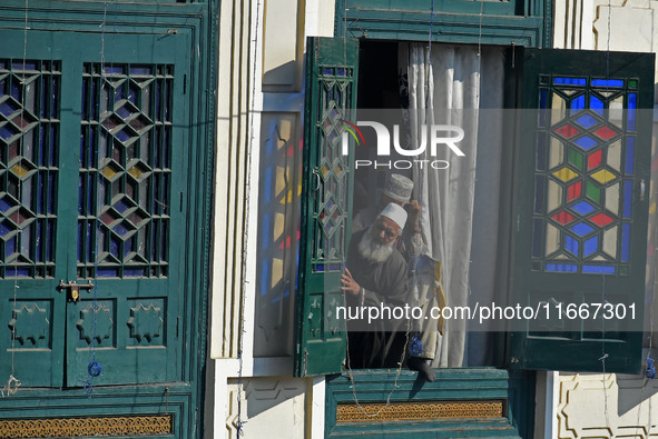 A devotee looks on as the head cleric (not in picture) displays the holy relic during the festival of Saint Sheikh Abdul Qadir Jeelani (RA)...