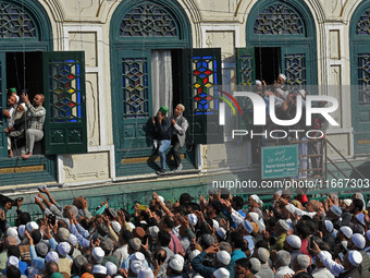 People pray as the head cleric (not in picture) displays the holy relic during the festival of Sufi Saint Sheikh Abdul Qadir Jeelani (RA) in...