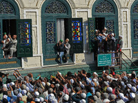 People pray as the head cleric (not in picture) displays the holy relic during the festival of Sufi Saint Sheikh Abdul Qadir Jeelani (RA) in...