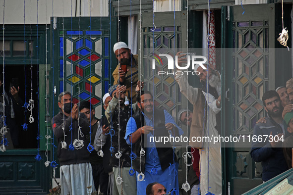 People pray as the head cleric (not in picture) displays the holy relic during the festival of Sufi Saint Sheikh Abdul Qadir Jeelani (RA) in...