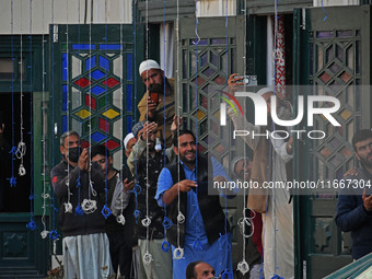 People pray as the head cleric (not in picture) displays the holy relic during the festival of Sufi Saint Sheikh Abdul Qadir Jeelani (RA) in...