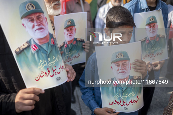 Iranian mourners hold portraits of a commander of the Islamic Revolutionary Guard Corps' (IRGC) Quds Force, Abbas Nilforoushan, who is kille...