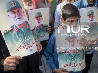 Iranian mourners hold portraits of a commander of the Islamic Revolutionary Guard Corps' (IRGC) Quds Force, Abbas Nilforoushan, who is kille...