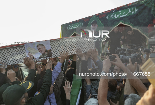 Iranian mourners carry a coffin containing the body of a commander of the Islamic Revolutionary Guard Corps' (IRGC) Quds Force, Abbas Nilfor...