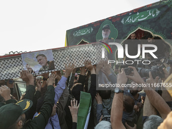 Iranian mourners carry a coffin containing the body of a commander of the Islamic Revolutionary Guard Corps' (IRGC) Quds Force, Abbas Nilfor...