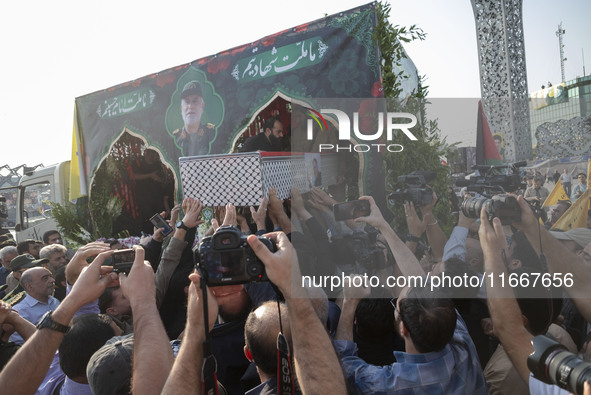 Iranian mourners carry a coffin containing the body of a commander of the Islamic Revolutionary Guard Corps' (IRGC) Quds Force, Abbas Nilfor...