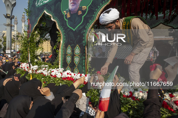 Veiled Iranian mourners take part in a funeral while a truck carries a coffin containing the body of a commander of the Islamic Revolutionar...