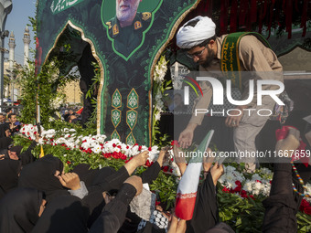 Veiled Iranian mourners take part in a funeral while a truck carries a coffin containing the body of a commander of the Islamic Revolutionar...