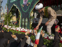 Veiled Iranian mourners take part in a funeral while a truck carries a coffin containing the body of a commander of the Islamic Revolutionar...