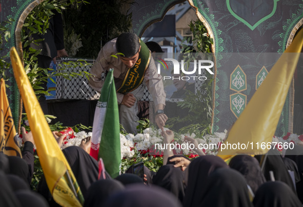 Veiled Iranian mourners take part in a funeral while a truck carries a coffin containing the body of a commander of the Islamic Revolutionar...