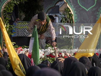 Veiled Iranian mourners take part in a funeral while a truck carries a coffin containing the body of a commander of the Islamic Revolutionar...