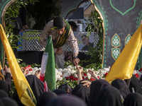 Veiled Iranian mourners take part in a funeral while a truck carries a coffin containing the body of a commander of the Islamic Revolutionar...